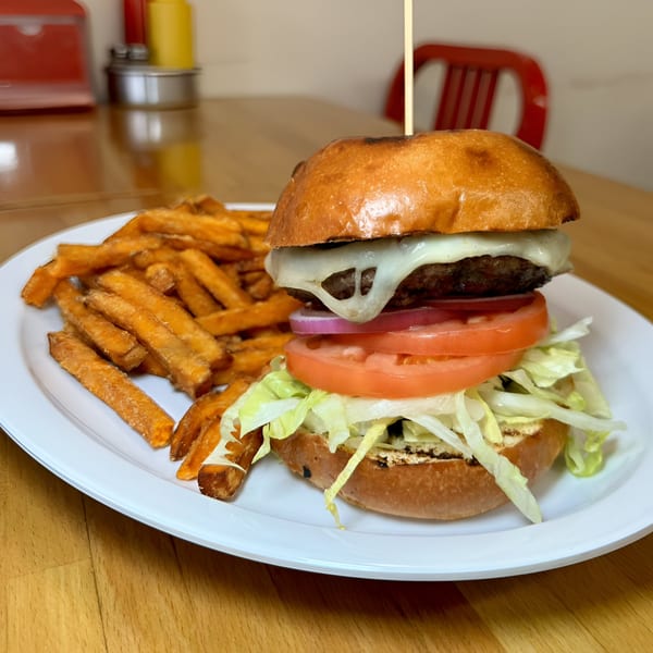 P.S. Burgers' cheeseburger with lettuce, tomato, onion, and a side of sweet potato fries.